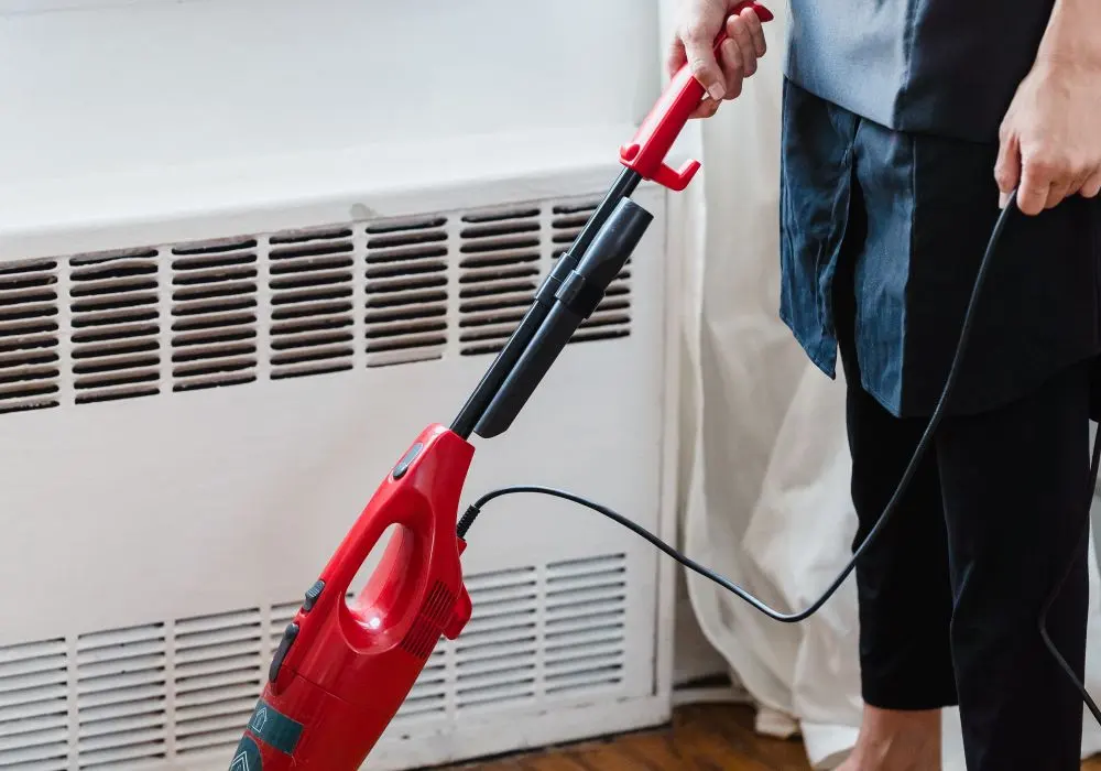 Vacuuming a wooden floor in a well-lit room